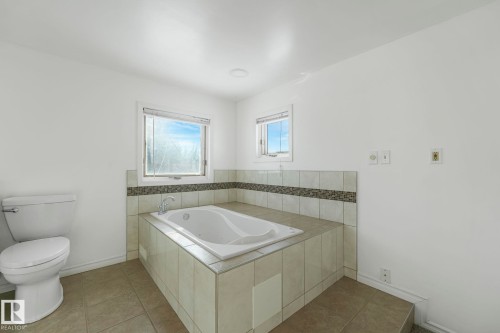 Full bath with a bath and light tile patterned floors - 13911 117 Avenue, Edmonton, AB - Indoor Photo Showing Bathroom