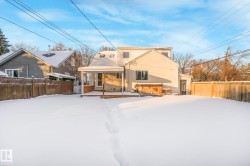 Snow covered house featuring a fenced backyard and a wooden deck - 