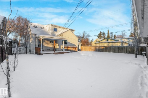 Snow covered rear of property featuring a fenced backyard and covered porch - 13911 117 Avenue, Edmonton, AB - Outdoor