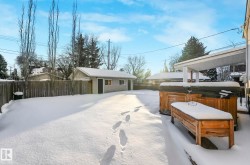 Yard layered in snow with a fenced backyard and an outbuilding - 