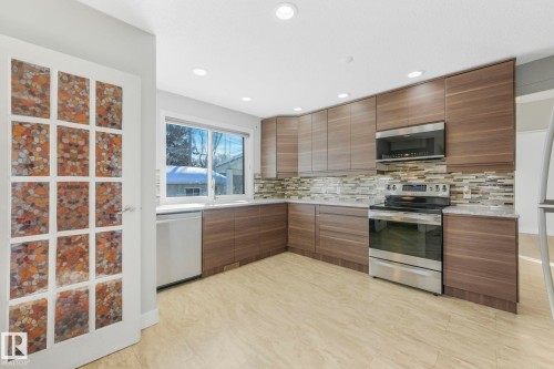 Kitchen with modern cabinets, stainless steel appliances, light stone counters, recessed lighting, and backsplash - 13911 117 Avenue, Edmonton, AB - Indoor Photo Showing Kitchen With Upgraded Kitchen
