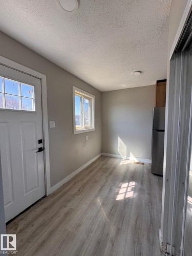 Entryway featuring wood-finish flooring, neutral wall paint, and white trim - 2910 132A Avenue, Edmonton, AB - Indoor