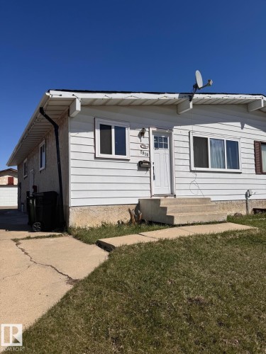 Front exterior featuring white siding, a white entry door, and multiple windows - 2910 132A Avenue, Edmonton, AB - Outdoor