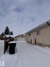 View of snowy exterior with stucco siding, an outbuilding, and a detached garage - 2910 132A Avenue, Edmonton, AB  - Outdoor With Exterior 