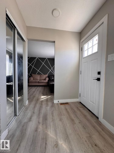Entryway featuring wood-finish flooring, a white paneled entry door with frosted glass inserts, and a recessed ceiling light - 2910 132A Avenue, Edmonton, AB - Indoor Photo Showing Other Room