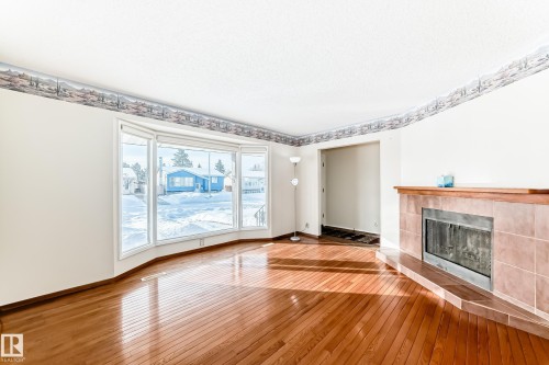 Unfurnished living room featuring hardwood / wood-style floors and a fireplace - 11922 138 Avenue, Edmonton, AB - Indoor With Fireplace