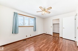 Unfurnished bedroom featuring a walk in closet, light wood-style floors, and ceiling fan - 