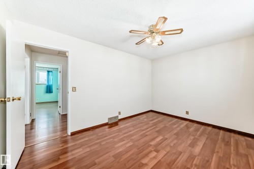 Spare room with wood finished floors, a ceiling fan, and a textured ceiling - 11922 138 Avenue, Edmonton, AB - Indoor Photo Showing Other Room