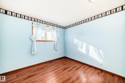 Unfurnished room featuring baseboards and wood finished floors - 