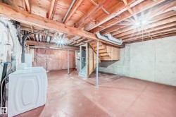 Unfinished below grade area with stairway and washer / dryer - 