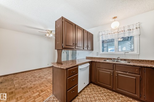 Kitchen with white dishwasher, a textured ceiling, pendant lighting, ceiling fan, and parquet floors - 11922 138 Avenue, Edmonton, AB - Indoor Photo Showing Kitchen With Double Sink