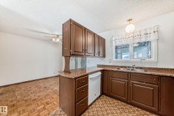 Kitchen with white dishwasher, a textured ceiling, pendant lighting, ceiling fan, and parquet floors - 