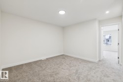 Empty room featuring baseboards and light carpet - 