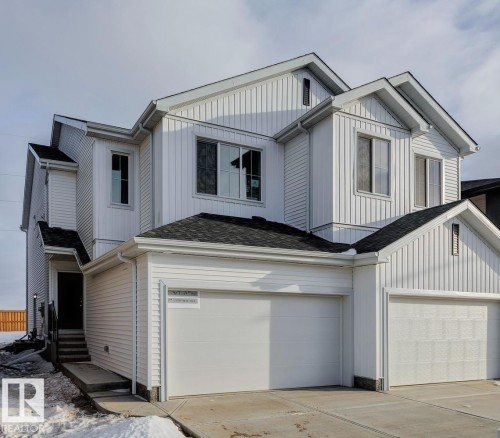 View of front of house featuring entry steps, a garage, driveway, and board and batten siding - 407 26 Street, Edmonton, AB - Outdoor
