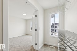 Hallway with light carpet and healthy amount of natural light - 