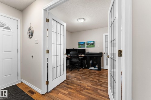 Office space featuring french doors, a textured ceiling, and dark wood-type flooring - 36 2204 118 Street, Edmonton, AB - Indoor Photo Showing Other Room