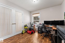 Office with a textured ceiling, wood finished floors, and french doors - 