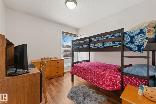 Bedroom featuring light wood-type flooring, a textured ceiling, and an office area - 36 2204 118 Street, Edmonton, AB - Indoor Photo Showing Bedroom