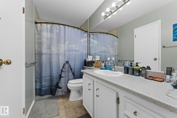Full bathroom with vanity, curtained shower, and stone finish floors - 