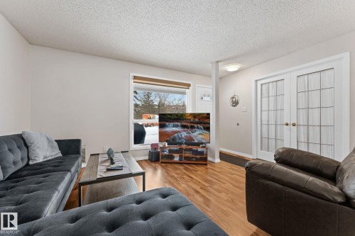 Living room with light wood finished floors and a textured ceiling - 36 2204 118 Street, Edmonton, AB - Indoor Photo Showing Living Room