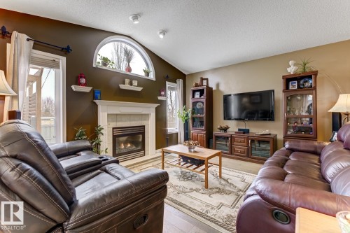 Living area with a tile fireplace and wood finished floors - 20148 46 Avenue, Edmonton, AB - Indoor Photo Showing Living Room With Fireplace