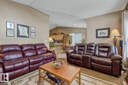 Living area featuring wood finished floors and suspended lighting - 