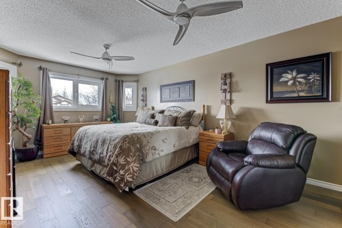 Bedroom featuring wood-type flooring, a textured ceiling, and ceiling fan - 20148 46 Avenue, Edmonton, AB - Indoor Photo Showing Bedroom