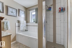 Full bath featuring vanity, a shower stall, and a jetted tub - 