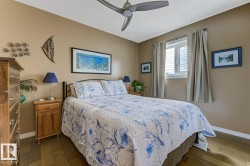 Bedroom featuring dark wood finished floors, ceiling fan, and a textured ceiling - 