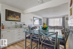 Dining area with a textured ceiling and light wood-type flooring - 