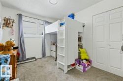 Bedroom featuring light colored carpet and a textured ceiling - 