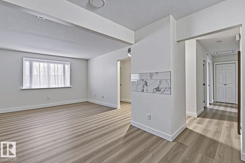 Spare room featuring a textured ceiling and light wood-style floors - 13211 71 Street, Edmonton, AB - Indoor Photo Showing Other Room