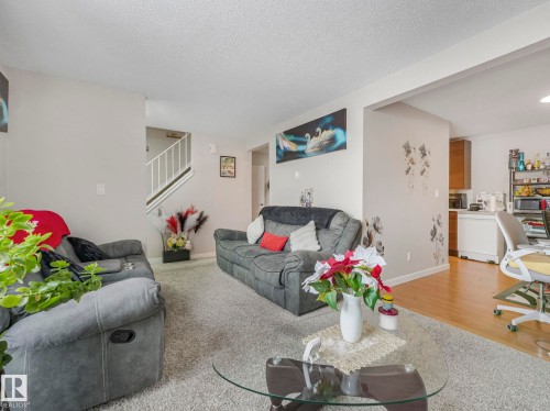 Living area featuring a desk, wood finished floors, and a textured ceiling - 13271 47 Street, Edmonton, AB - Indoor Photo Showing Living Room