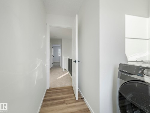 Laundry area featuring washer / dryer and light wood-type flooring - 20506 16A Avenue, Edmonton, AB - Indoor Photo Showing Laundry Room