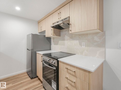 Kitchen featuring light wood finish cabinetry, stainless steel electric range oven, modern cabinets, light wood-style flooring, and recessed lighting - 20506 16A Avenue, Edmonton, AB - Indoor Photo Showing Kitchen
