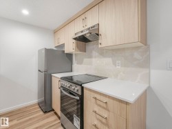 Kitchen featuring light wood finish cabinetry, stainless steel electric range oven, modern cabinets, light wood-style flooring, and recessed lighting - 