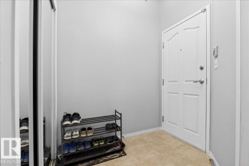 Entrance foyer with baseboards and light tile patterned floors - 105 9707 105 Street, Edmonton, AB - Indoor Photo Showing Other Room