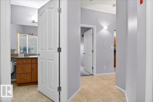 Hallway with light tile patterned floors and a textured ceiling - 105 9707 105 Street, Edmonton, AB - Indoor Photo Showing Other Room