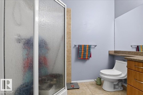 Bathroom featuring vanity, a stall shower, and light tile patterned floors - 105 9707 105 Street, Edmonton, AB - Indoor Photo Showing Bathroom