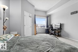 Bedroom featuring carpet floors, a textured ceiling, an office area, and a baseboard heating unit - 