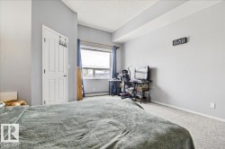 Carpeted bedroom with a textured ceiling and a baseboard radiator - 