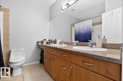 Full bath with double vanity, light tile patterned flooring, and curtained shower - 