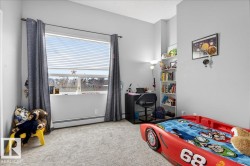 Bedroom with light carpet, baseboard heating, and a textured ceiling - 
