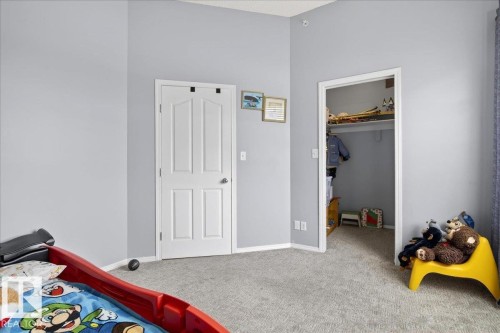 Bedroom with carpet flooring and a spacious closet - 105 9707 105 Street, Edmonton, AB - Indoor