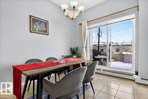 Dining area with hanging lights, baseboard heating, and light tile patterned flooring - 105 9707 105 Street, Edmonton, AB - Indoor Photo Showing Dining Room