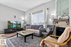 Living area featuring a tile fireplace, a textured ceiling, and baseboard heating - 