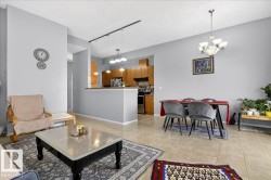 Living room with hanging lights, a textured ceiling, and light tile patterned floors - 