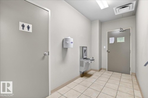 Entryway with light tile patterned flooring and baseboards - 105 9707 105 Street, Edmonton, AB - Indoor Photo Showing Other Room