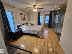 Bedroom featuring light wood-type flooring, a textured ceiling, access to outside, and ceiling fan - 