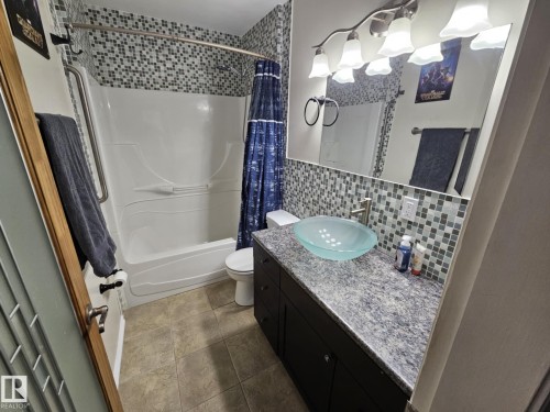 Bathroom with vanity, shower / bath combo with shower curtain, and backsplash - 8512 131 Avenue, Edmonton, AB - Indoor Photo Showing Bathroom